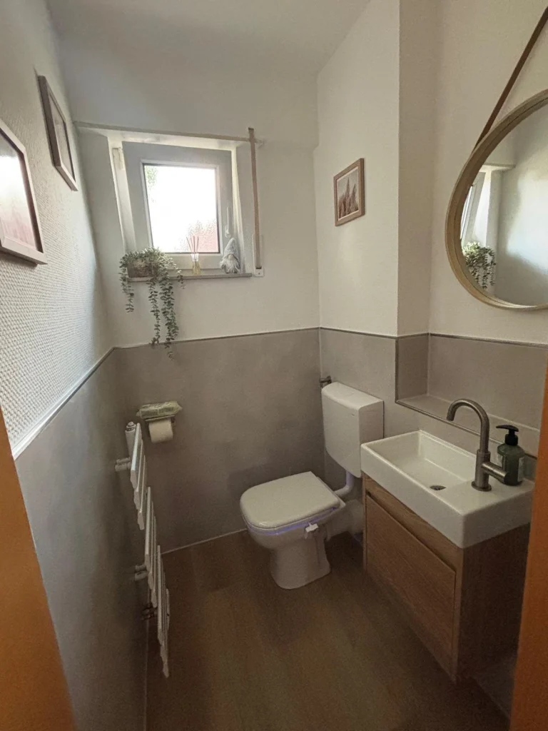 Gäste-WC mit Holzwaschtisch und halbhohen Wandfliesen