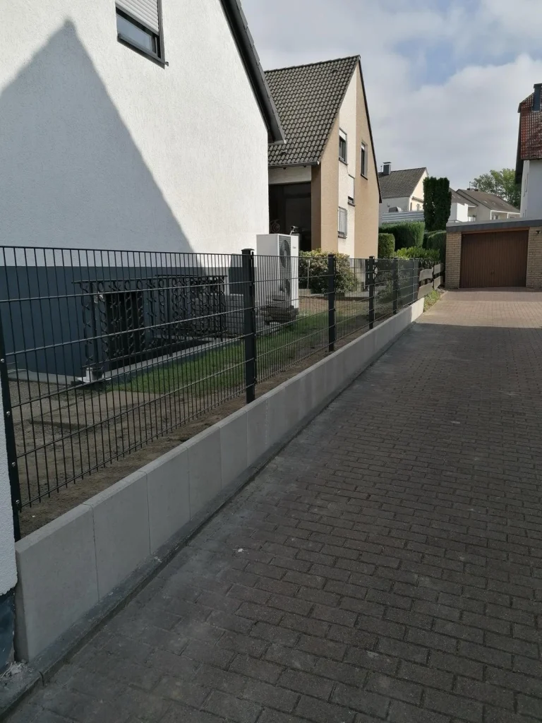 Stützmauer mit neuem Zaun an der Einfahrt